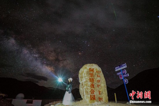 圖為6月20日晚，游客“打卡”西藏阿里暗夜公園，天上是銀河與流星（右上角）。曹枝清 攝