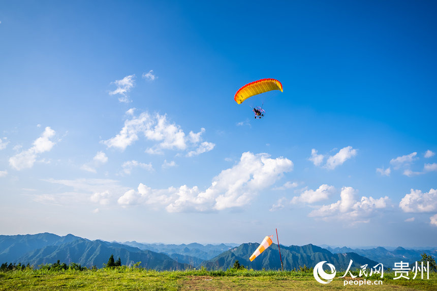 游客在野玉海飛行營地乘動力滑翔傘體驗(yàn)云端觀景。人民網(wǎng)記者 涂敏攝